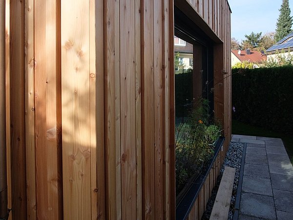 Foto, mit Holz verkleidete Fassade mit Fenster. 