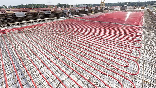 Foto, Rohrleitungen bedecken die Armierung einer großen, neu zu gießenden Betondecke.