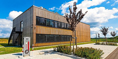 Foto, Außenansicht der mit Holz verkleideten Forschungshalle in Feuchtwangen.