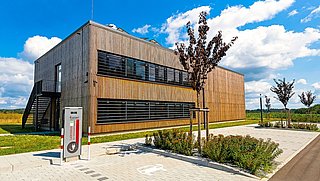 Foto, Außenansicht der mit Holz verkleideten Forschungshalle in Feuchtwangen.
