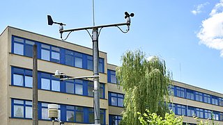 Foto, Klimastation im Schulgarten der Paul-Robeson-Schule vor dem Schulgebäude