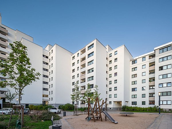 Foto, Innenhof einer modernen Wohnsiedlung aus Mehrfamilienhäusern mit einem Spielplatz