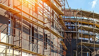 Foto, Blick auf die eingerüstete Fassade eines Gebäudes im Bau.