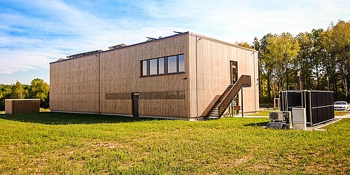 Foto, Außenansicht der mit Holz verkleideten Forschungshalle in Feuchtwangen