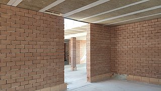 Foto, Rohbau mit Wände aus Hohlziegeln und einer Holz-Lehm-Decke