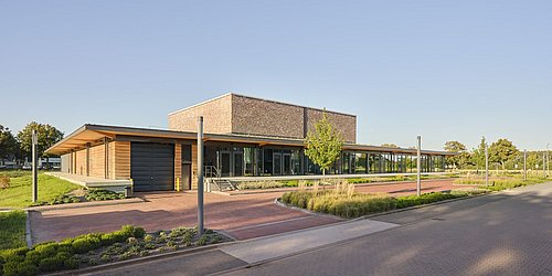 Foto, Außenansicht eines modernen, einstöckigen Flachbaus aus Holz mit großen Fensterfronten.