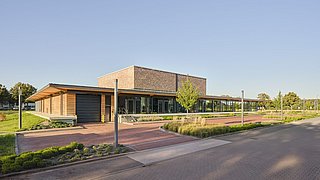 Foto, Außenansicht eines modernen, einstöckigen Flachbaus aus Holz mit großen Fensterfronten.