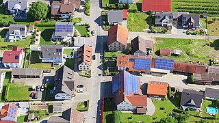 Foto, Blick von oben auf eine Siedlung, mehrere Häuser verfügen über eine Solaranlage auf dem Dach.