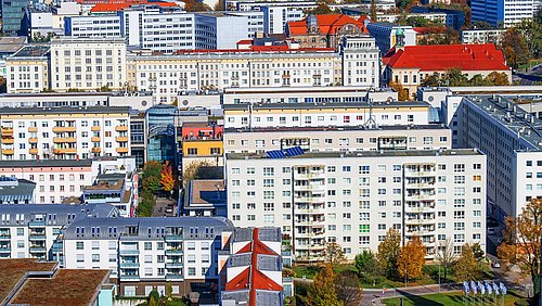 Foto, Blick von oben auf eine urbanes Gebiet mit mehreren sanierten Plattenbauten.