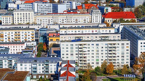 Foto, Blick von oben auf eine urbanes Gebiet mit mehreren sanierten Plattenbauten.