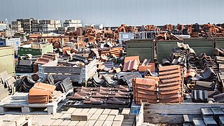 Foto, großes Lager mit gestapelten Dachziegeln und Baumaterialien auf Paletten im Freien