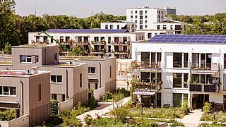 Foto, mehrere Gebäude eines nachhaltigen Quartiers, auf dem Dach eines Gebäudes befindet sich eine PV-Anlage.