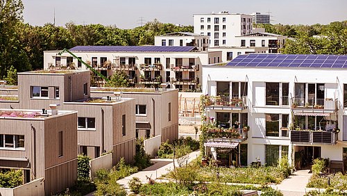 Foto, mehrere Gebäude eines nachhaltigen Quartiers, auf dem Dach eines Gebäudes befindet sich eine PV-Anlage.