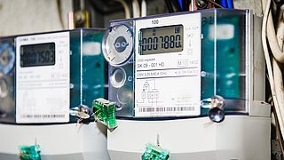Foto, Zwei intelligente Stromzähler mit grünen Plomben und Schlüsseln versehen.