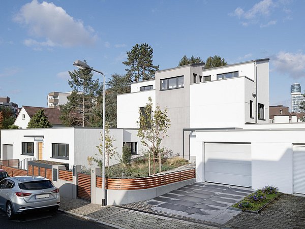 Foto, Außenansicht eines modernen Mehrfamilienhauses mit flachem Vorbau und Garagen