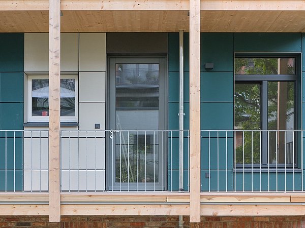 Foto, Detailansicht einer modernen Fassade mit Holzrahmen, Glasfenstern und Metallgeländer