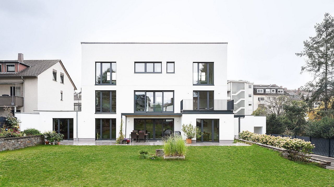 Foto, Außenansicht eines dreigeschossigen, modernen Einfamilienhauses mit Garten