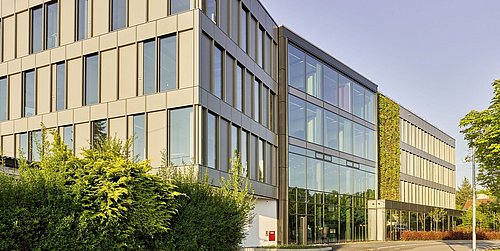 Foto, Außenaufnahme von Bürogebäude mit Fensterfläche und begrünter Fassade
