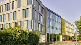 Foto, Außenaufnahme von Bürogebäude mit Fensterfläche und begrünter Fassade