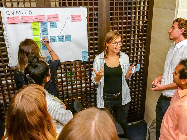 Foto, Gruppe von Menschen vor einem Plakat stehend
