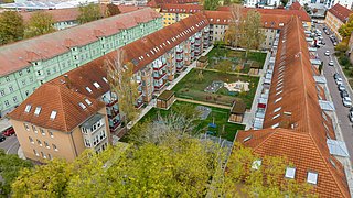 Foto, Luftaufnahme eines U-förmigen Mehrfamilienhauses mit Innenhof.