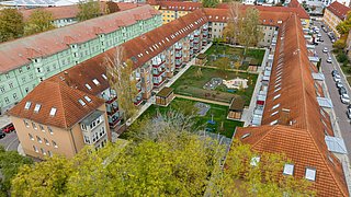 Foto, Luftaufnahme eines U-förmigen Mehrfamilienhauses mit Innenhof.