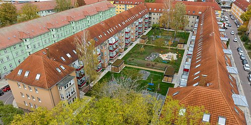 Foto, Luftaufnahme eines U-förmigen Mehrfamilienhauses mit Innenhof.