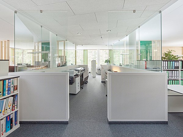 Foto, Helles, modernes Büro mit Glaswänden, grauen Trennwänden, Regalen mit Ordnern und mehreren Druckern