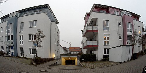Foto, Zwei moderne Wohngebäude mit Balkonen und großen Fenstern, dazwischen eine Einfahrt zu einer Tiefgarage