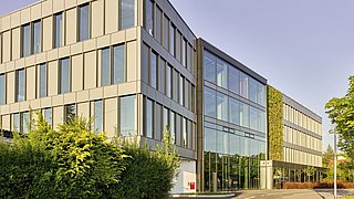 Foto, Außenaufnahme von Bürogebäude mit Fensterfläche und begrünter Fassade