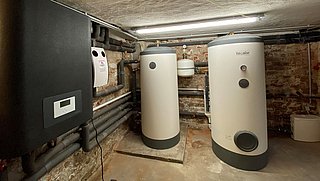 Foto, Anlagenraum im Keller mit großen Kesseln