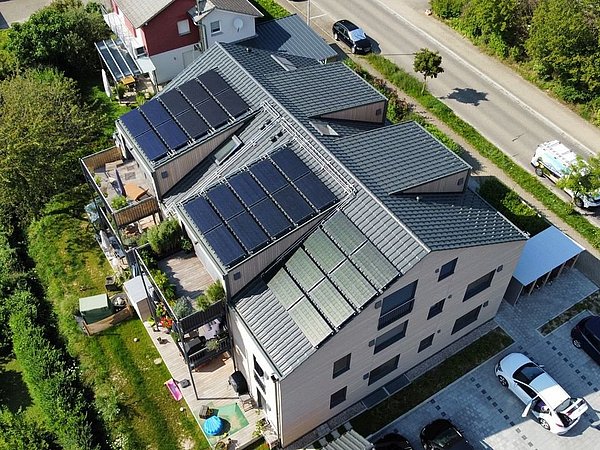 Foto, Vogelperspektive auf Mehrfamilienhaus mit Photovoltaik-Kollektoren auf dem Dach.