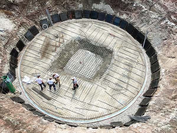 Foto, Luftaufnahme einer Baustelle eines großen, runden Eisspeichers im Boden.