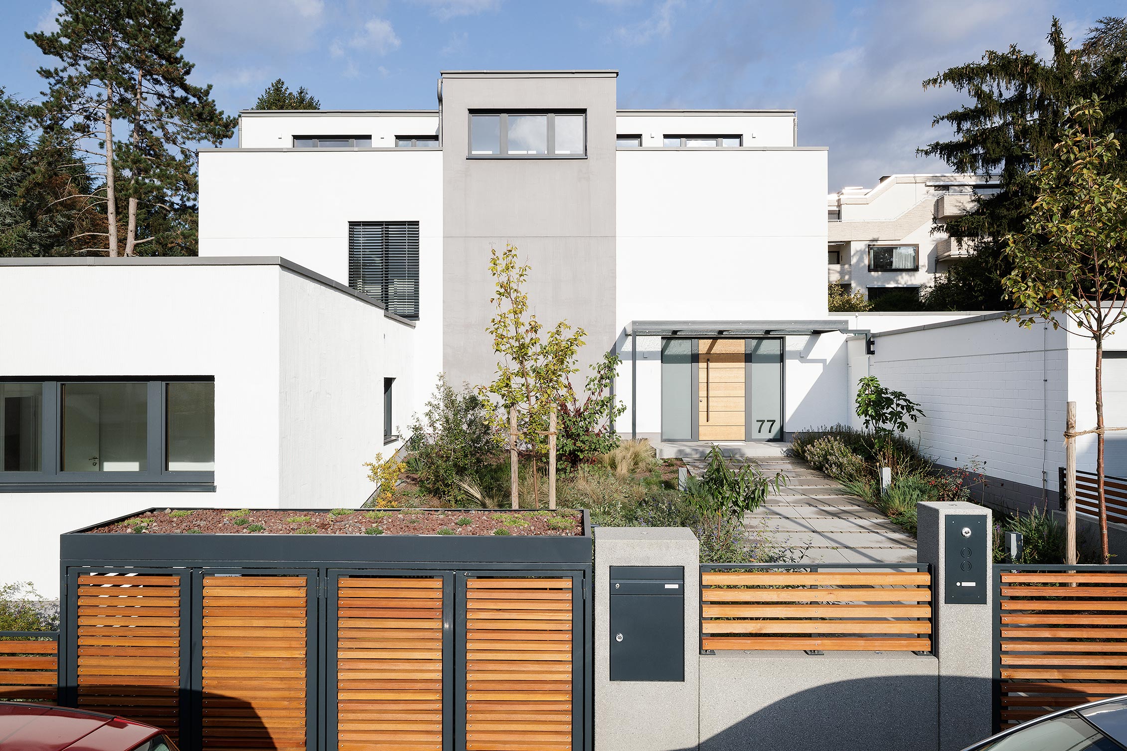 Foto, Straßenansicht auf ein modernen Einfamilienhaus mit großem Holztor im Vordergrund