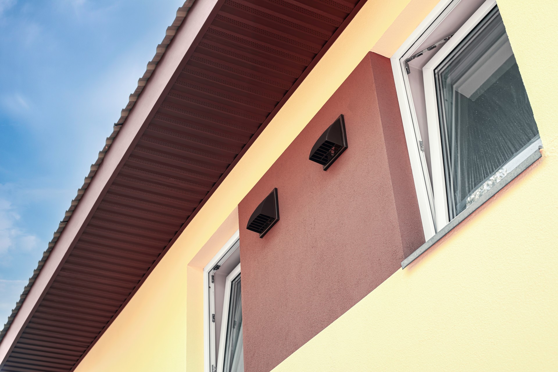 Foto, Gebäudefassade mit geöffeneten Fenstern und Lüftungseinlässen.