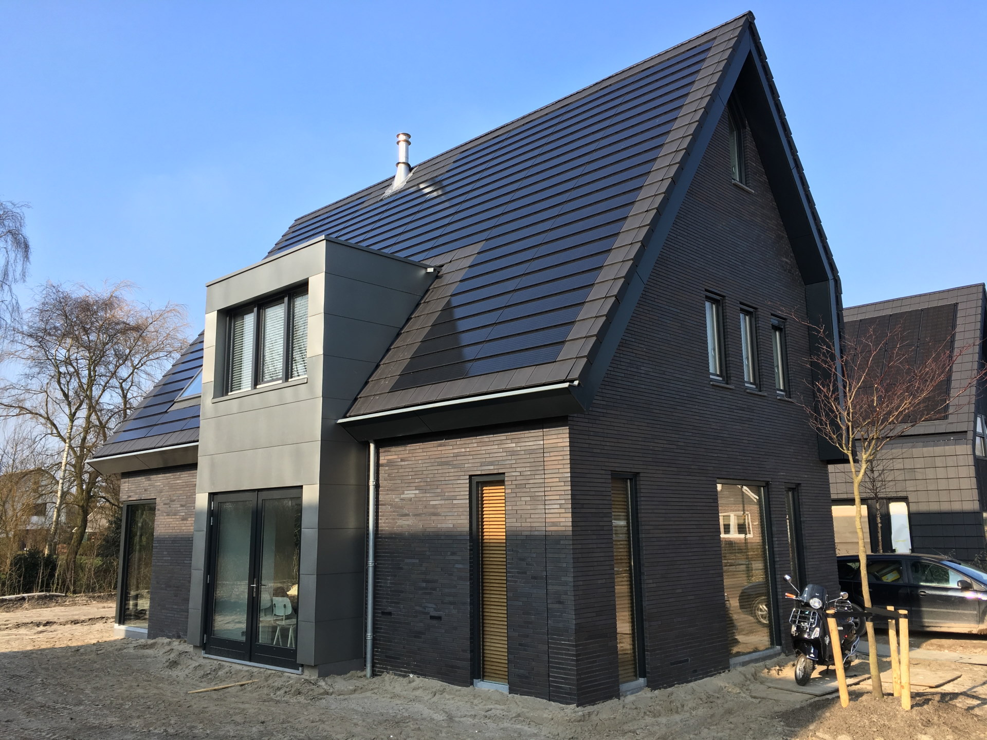 Foto, Neubau eines Einfamilienhauses, das Dach ist mit modernen Solarziegeln gedeckt.