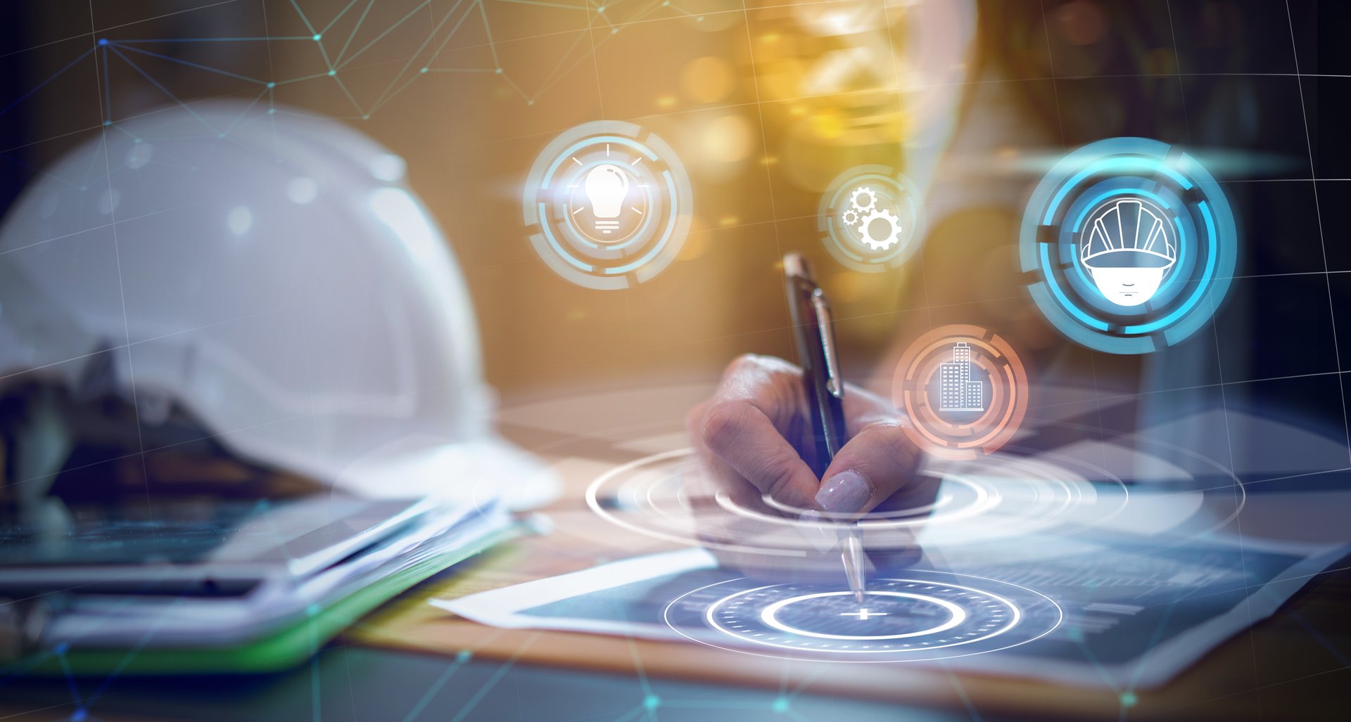 Foto, Nahaufnahme eine Tisches, auf dem ein Sicherheitshelm sowie Unterlagen liegen. Eine Hand zeichnet mit Kugelschreiber auf ein Dokument. Symbole eines Helmes, von Zahrädern und einer Glühbirne umgeben die Hand.